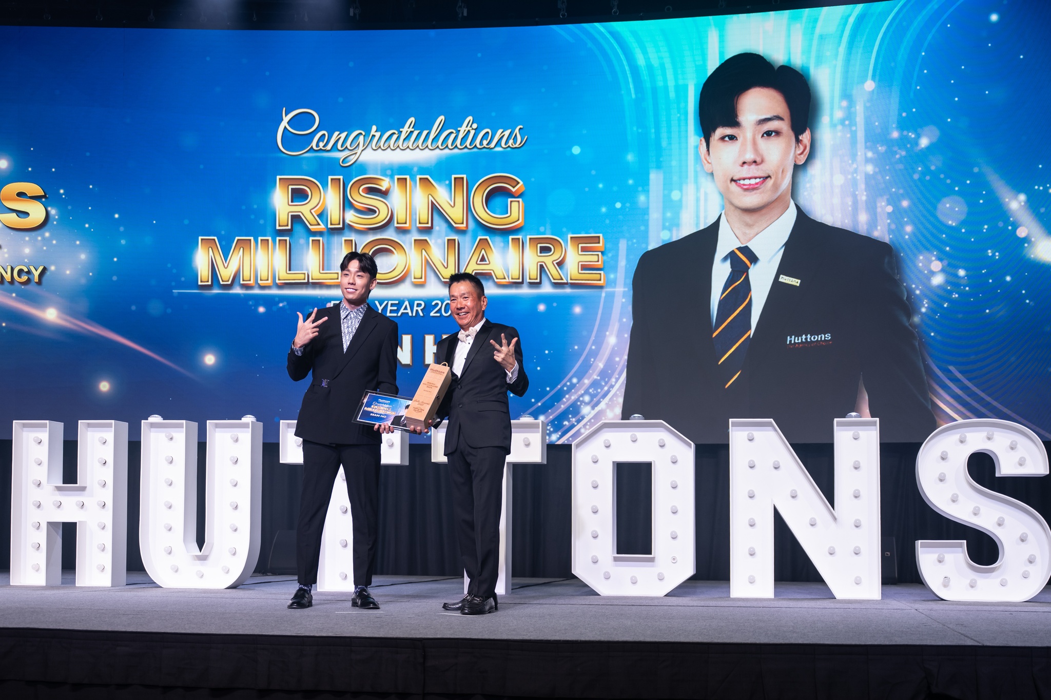 Sean Ho on stage receiving the Rising Millionaire award at the Huttons Asia gala